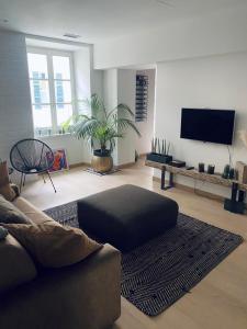 a living room with a couch and a flat screen tv at CASA JACK Open Space Piazza Galimberti in Cuneo