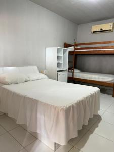 a bedroom with a large bed and two bunk beds at Pousada Sol Dourado in Jijoca de Jericoacoara +60 photos