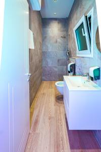 une salle de bain avec un lavabo blanc et des toilettes dans l'établissement Lumeris lakeview Suites and SPA, à Rubjekë