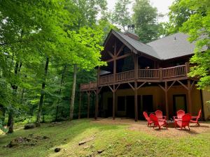 una casa con sillas rojas delante en The Feisty Fox, en Sugar Mountain