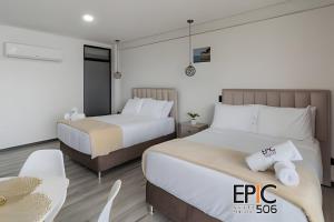 a hotel room with two beds and a table at Epic Suite 506 Deluxe Aeropuerto in Cuba