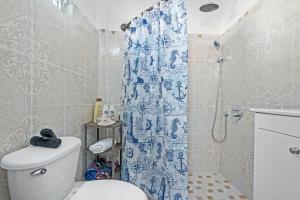 a bathroom with a blue shower curtain and a toilet at Balcony Pet-friendly Parking Leisure in Beltran