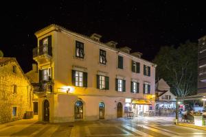 a large white building on a city street at night at Piano Nobile Rooms in Split