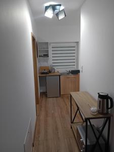 a small kitchen with a table and a counter top at Domek Pod Lipą in Jankowce