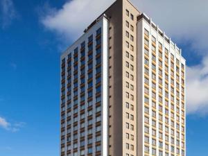 a tall building with a blue sky in the background at Mercure Belo Horizonte Lourdes in Belo Horizonte