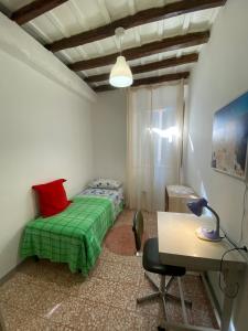 a bedroom with a green bed and a desk at La Casa di Antonella in Frascati