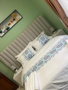 een bed met kussens erop in een slaapkamer bij J&D Home NTINDA 02 in Kampala