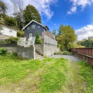 a blue house with a fence and a yard at Luxury & Central Arendal Home in Arendal