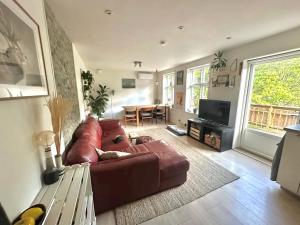 a living room with a brown leather couch and a table at Luxury & Central Arendal Home in Arendal