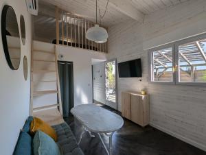 a living room with a couch and a table at Esprit Cabane au Cœur du Teich in Le Teich