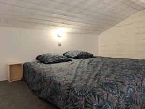 a bedroom with a bed with two pillows on it at Esprit Cabane au Cœur du Teich in Le Teich