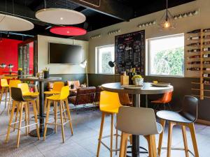 フエンラブラダにあるIbis Madrid Fuenlabradaの黄色い椅子とテーブルが備わるレストラン