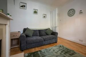 un salon avec un canapé et une horloge au mur dans l'établissement Rochdale Residence, à Royal Tunbridge Wells