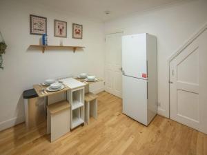 Elle comprend une petite cuisine équipée d'un réfrigérateur blanc et d'une table. dans l'établissement Rochdale Residence, à Royal Tunbridge Wells 46 autres photos