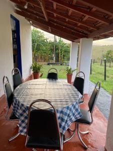 Una mesa con sillas y un mantel a cuadros en un patio. en Fazenda Brasileiro, en Passos