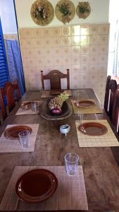 a wooden table with plates and glasses on it at Fazenda Brasileiro in Passos