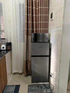 een keuken met een magnetron en een koelkast bij J&D Home NTINDA 02 in Kampala