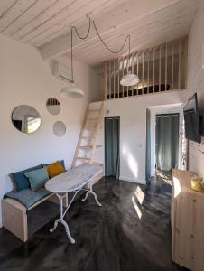 a room with a table and a couch and a ladder at Esprit Cabane au Cœur du Teich in Le Teich