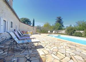 a group of chairs sitting next to a swimming pool at Chambre Ephedra in Sampzon