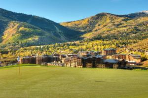 a golf course with a resort and mountains in the background at Grand Summit Lodge by Park City - Canyons Village in Park City