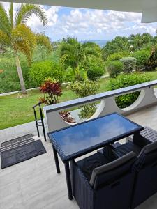 a table and chairs on a patio with a view of the ocean at LaBelleVue Antigua Oceanview Suites and OnSite Car Rentals in Crosbies +53 photos
