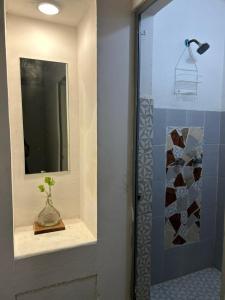 a bathroom with a mirror and a vase with a plant at Canova Hostel & Pizza in Puerto Vallarta +124 photos