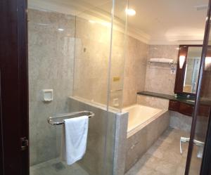 een badkamer met een douche, een bad en een wastafel bij Eco suites at times square in Kuala Lumpur