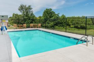 a swimming pool with a fence around it at Super 8 by Wyndham Warrensburg in Warrensburg