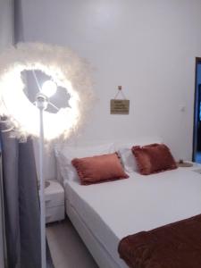 a bedroom with a bed with white sheets and a fan at Appartement fun in Dakar