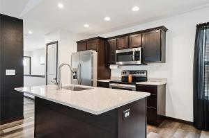 una cocina con fregadero y refrigerador en Newly built single family home, en Cedar Rapids