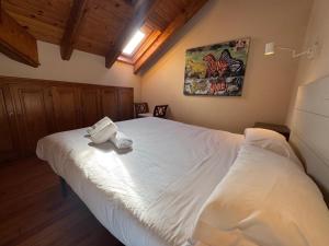 een slaapkamer met een wit bed met een handdoek erop bij B15 - Ático Los Copos - Villmor in Benasque