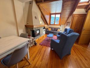 een woonkamer met een tafel, stoelen en een open haard bij B15 - Ático Los Copos - Villmor in Benasque