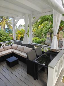 a screened in porch with a couch and a table at LaBelleVue Antigua Oceanview Suites and OnSite Car Rentals in Crosbies