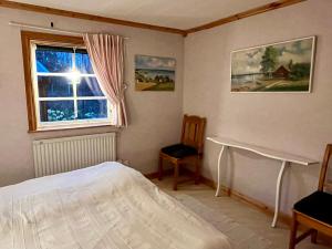 a bedroom with a bed and a window at StugaNäraKungsberget - mysig stuga med kamin, grillkåta och vedbastu in Ockelbo