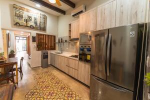 a kitchen with a stainless steel refrigerator and wooden cabinets at Casa Mariano Merida by WoWay Experiences in Mérida
