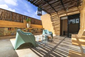 a patio with two chairs and a table at Casa Mariano Merida by WoWay Experiences in Mérida