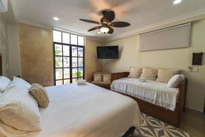 a bedroom with two beds and a ceiling fan at Casa Mariano Merida by WoWay Experiences in Mérida +32 photos