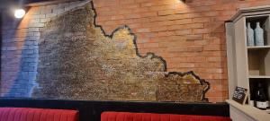 a brick wall with a painting on it at Lia parking rénové proche cité congrès cocon cosy 24m2 in Anzin