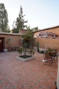 a patio with a table and chairs and an umbrella at Riad Beldi by MaHa in Oulad Teïma