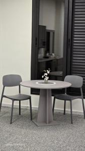 een tafel met twee stoelen en een tafel met bloemen erop bij Jeeso hotel in Jerash