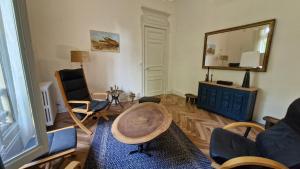 a living room with a table and a mirror at Le Manoir de la Belle Endormie in Valréas +9 photos