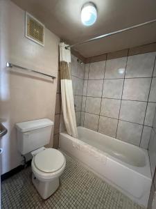 een badkamer met toilet en ligbad bij Central Motel Kissimmee Near Disney World in Kissimmee