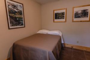 un piccolo letto in una stanza con due immagini sul muro di Frio Country #17 a Concan 1 altra foto