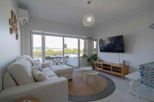un salon avec un canapé et une télévision dans l'établissement Feel The Ocean Apartment - Praia Do Cabedelo, à Viana do Castelo