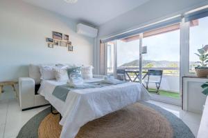 une chambre blanche avec un lit et une grande fenêtre dans l'établissement Feel The Ocean Apartment - Praia Do Cabedelo, à Viana do Castelo