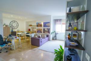 a living room with a purple couch and a dining room at B&B Porta di Ponte in Agrigento