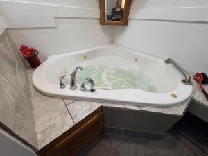 a bath tub with two faucets in a bathroom at 2 Story Home in the Noto Arts District in Topeka