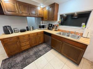 a kitchen with wooden cabinets and a sink at 2 Story Home in the Noto Arts District in Topeka