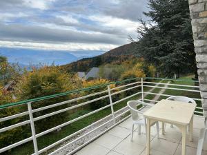 Saint-Nizier-du-Moucherotteにあるluxurious villa in an enchanting settingの眺めの良いバルコニーにテーブルと椅子が置かれている