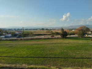 a field of grass with a road in the distance at Gianis Homme in Alexandroupoli